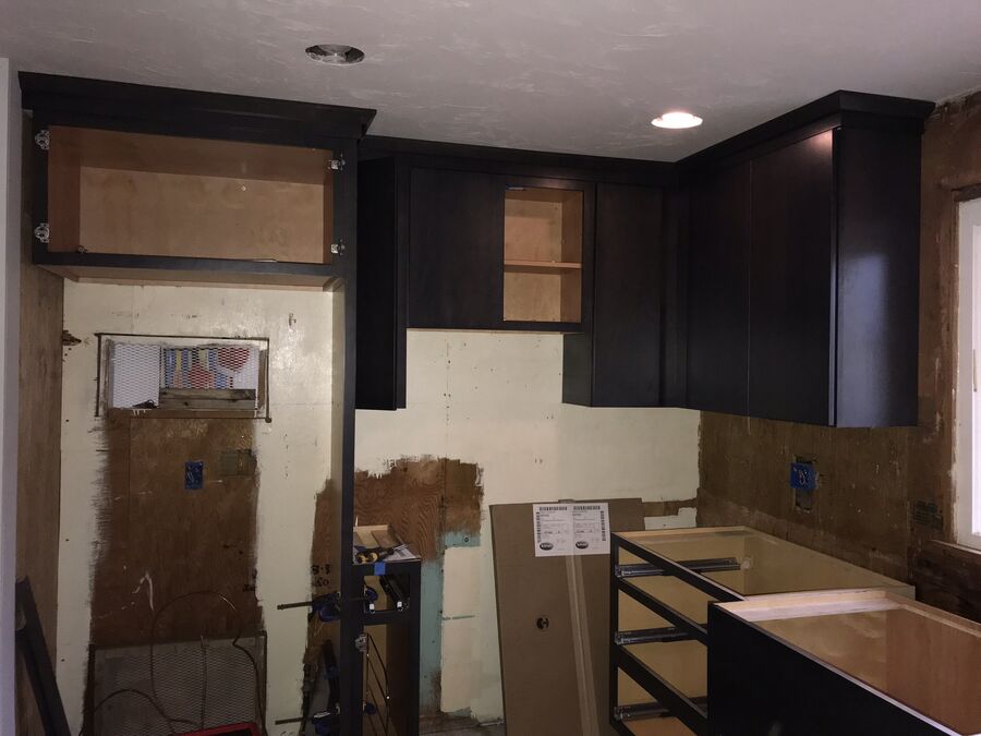 Kitchen before remodeling, with worn cabinets and dated finishes