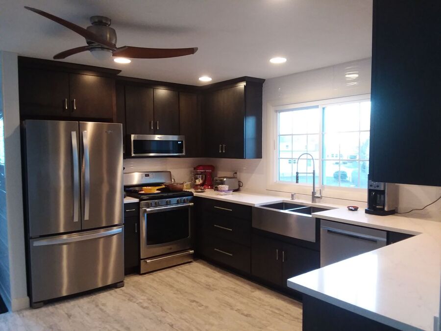 Finished kitchen remodel with dark cabinets and stainless appliances