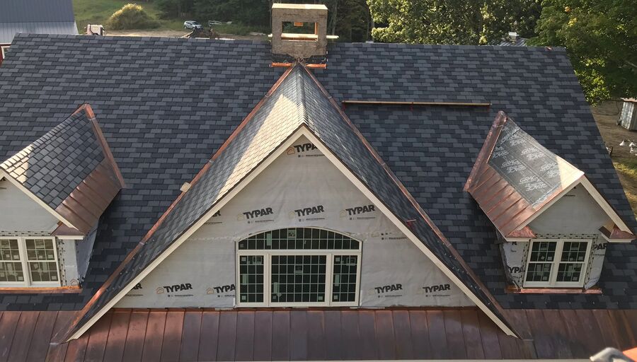 Newly shingled roof on a stone-front home